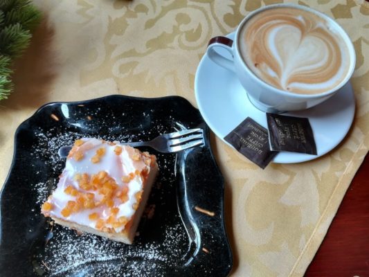 Una fetta di torta e un cappuccino in un caffè di Breslavia